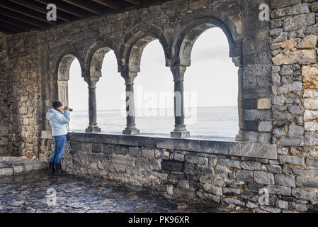 Donna turista femminile di scattare foto con una fotocamera dalla loggia di San Pietro, Portovenere e le Cinque Terre, Liguria, Italia Foto Stock