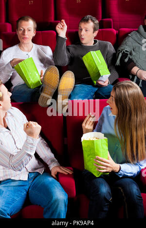 Persone mangiare popcorn in teatro Foto Stock