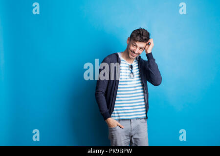Ritratto di un allegro giovane uomo che indossa abiti casual in studio. Foto Stock