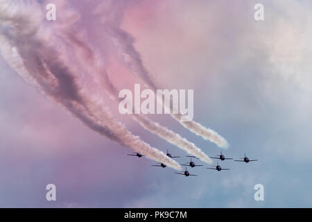 Il cielo diventa rosa dal fumo delle scie di frecce rosse aerobatic team display Foto Stock