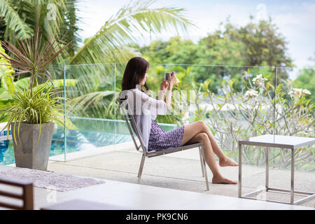 Felice giovane donna rilassante sul balcone Foto Stock