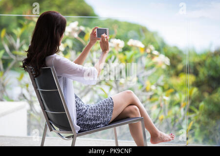 Felice giovane donna rilassante sul balcone Foto Stock