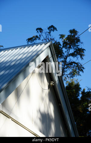 Energia elettrica i cavi di alimentazione che arrivano a una piccola casa di campagna nelle zone rurali del Nuovo Galles del Sud, Australia Foto Stock