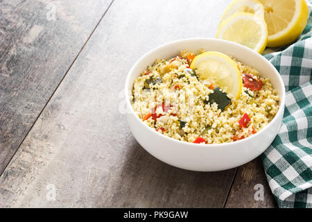 Il couscous con verdure nella ciotola sul tavolo di legno. Copyspace Foto Stock