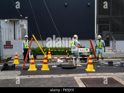 Giapponese dei lavoratori la riparazione della strada, Prefettura di Ishikawa, Kanazawa, Giappone Foto Stock