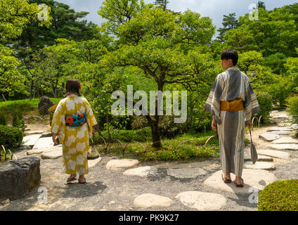 Coppia giapponese in uno yukata visitando la prugna grove in il Kenroku-en giardino, Ishikawa Prefettura, Kanazawa, Giappone Foto Stock