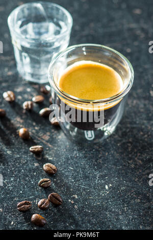 Expresso cup e i chicchi di caffè sul vecchio tavolo in legno. Foto Stock