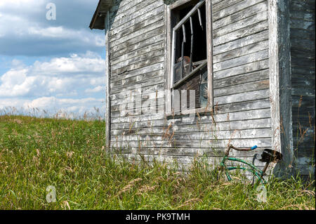 Rurale scena con non verniciata capannone abbandonato e bicicletta Foto Stock