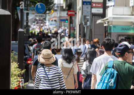 Le persone camminano giù Omotoesando la strada dello shopping di Harajuku a Tokyo di Shibuya. Foto Stock