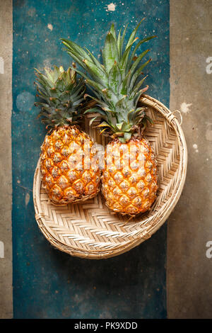 Due ananas in un cesto di vimini, vista dall'alto Foto Stock