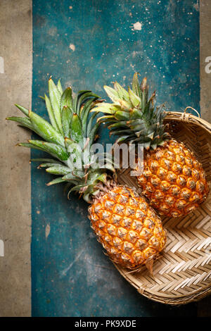 Due ananas in un cesto di vimini, vista dall'alto Foto Stock