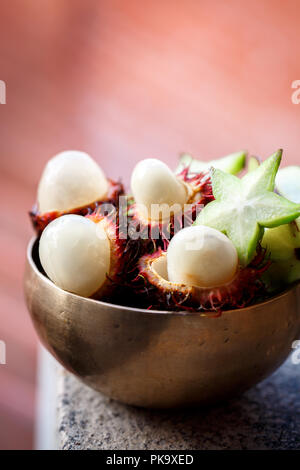 Esotica frutta pelosi rambutan in stile rustico Foto Stock