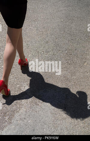Vista posteriore in prossimità di una donna in corsa di distanza su strada Foto Stock
