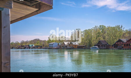 Piccole case in legno e i ristoranti sulla riva del fiume del Ada del fiume Bojana vicino a Ulcinj, Montenegro Foto Stock