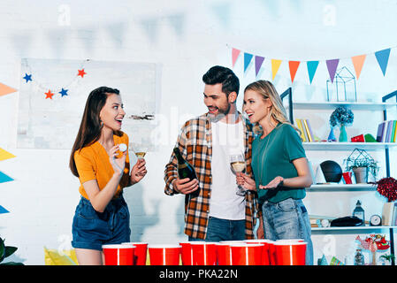 Felice giovani amici giocare Pong della birra in casa party Foto Stock