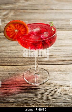 Arancio sanguigno Margarita cocktail con ghiaccio e timo sul vecchio backgorund in legno Foto Stock