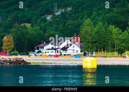 Case norvegesi, tende vicino al villaggio e fiordo Sognefjord paesaggio in Flam, Norvegia. Turismo Viaggi e vacanze sfondo Foto Stock