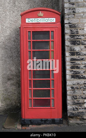 Defibrillatore Uk in un vecchio tradizionale telefono rosso box ora non più in uso per effettuare chiamate telefoniche ma utilizzato per tenere i defibrillatori per uso pubblico. Inghilterra 2010s. HOMER SYKES Foto Stock