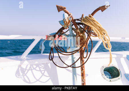 Rusty ancore sulla barca coperta al sole con il mare in background Foto Stock