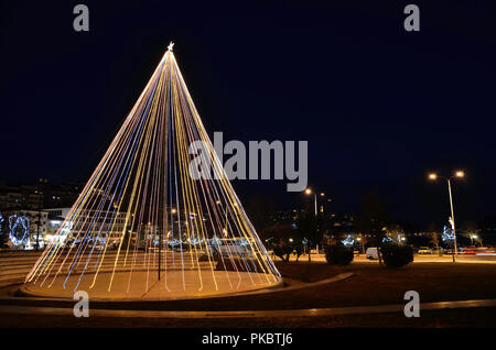 Albero di natale nel parco in Kastoria , Grecia e sentieri di luce di auto Foto Stock