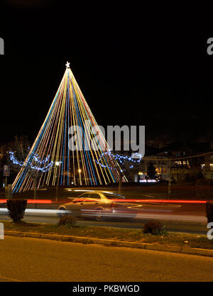 Albero di natale nel parco in Kastoria , Grecia e sentieri di luce di auto Foto Stock