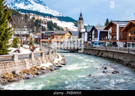 Il villaggio di Lech nella neve con il fiume Lech in primo piano, Arlberg, Austria, a Foto Stock