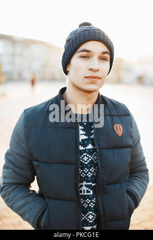 Giovane uomo bello in una giornata invernale e in un abbigliamento caldo al tramonto Foto Stock