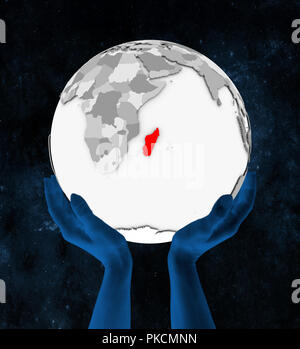 Madagascar in rosso su bianco globe tenutosi a mani nello spazio. 3D'illustrazione. Foto Stock