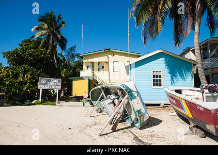 Capovolto barche e palme nella parte anteriore del Caye Caulker stazione di polizia Foto Stock