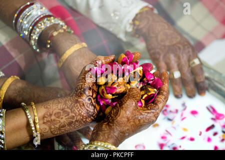 Senior donna con Henna Tattoos su entrambe le mani di rosa fiori ed erbe bagnato nel latte per un paio di passare. Foto Stock