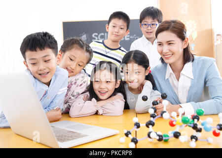 Donne insegnanti e studenti utilizzano i computer in classe Foto Stock