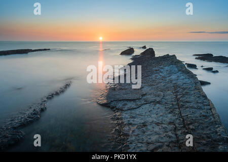 Tramonto su una calma alba del Mare del Nord a Howick cicatrice sulla costa di Northumberland vicino Craster e Alnwick Foto Stock