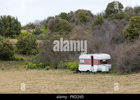 Vecchio rimorchio desolata in piedi su un pascolo in una giornata nuvolosa in primavera (Isola di Cres, Croazia) Foto Stock