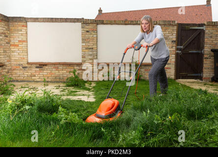 Donna falciatura prato sovradimensionate Foto Stock