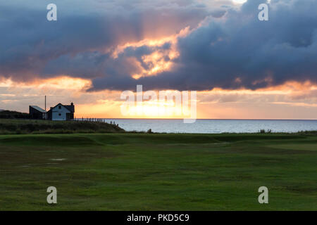 Sunset rottura attraverso le nuvole scure su costa North Antrim, Portstewart, N.Irlanda. Foto Stock