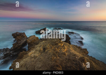 Incredibile a lungo vista di esposizione di liscio onde si infrangono in formazioni rocciose a Sequit punto dopo il tramonto, Leo Carrillo State Beach, Malibu, California Foto Stock