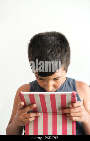 Male gli occhi-bambino gioca giochi ona tablet tablet Foto Stock