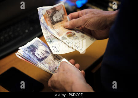 Il conteggio di cash-Pound sterling Banconote Foto Stock