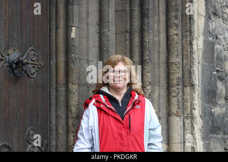 Matura donna irlandese espressioni, ritratto contro un edificio antico. Foto Stock