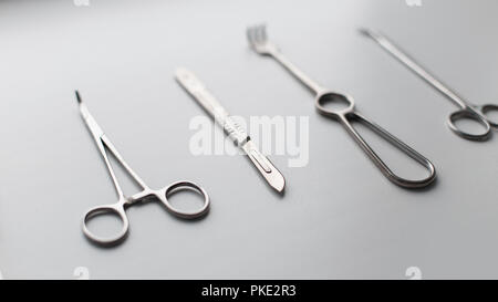 Set di metallo di strumenti medici (lama di bisturi, forbici, pinze, morse pinze) su uno sfondo bianco Foto Stock