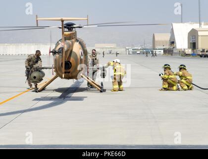 KABUL, Afghanistan (25 luglio 2018) -- Un Afghan Air Force pompiere disabilita le armi del MD-530 durante l'esercizio egress Luglio 25, 2018, Kabul Air Wing, Afghanistan. I vigili del fuoco hanno insegnato a scollegare i sistemi di armamenti e girare il velivolo off prima uscente i piloti. Foto Stock