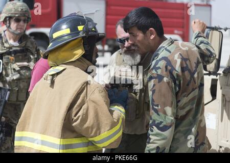 KABUL, Afghanistan (25 luglio 2018) -- Un Afghan Air Force pompiere passa le informazioni ad un medic durante il MD-530 esercizio egress Luglio 25, 2018, Kabul Air Wing, Afghanistan. Come parte del corso di formazione, il vigile del fuoco necessari per essere in grado di fornire le informazioni pertinenti per i medici. Foto Stock