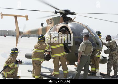 KABUL, Afghanistan (25 luglio 2018) Un Afghan Air Force vigile del fuoco esce la finta inabile pilota durante il MD-530 esercizio egress Luglio 25, 2018, Kabul Air Wing, Afghanistan. Ciò era parte di una due giorni di esercizio che si è concentrato sul lavoro in condizioni pericolose. Foto Stock