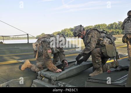 Stati Uniti La riserva di esercito di PFC. Christopher Thompson, sinistra e SPC. Giacobbe sfera con il 739th multiruolo società Ponte, la città di granito, Ill., allentare le fascette su un nastro migliorate rampa a ponte come esso galleggia sull'Arkansas River vicino a Fort Chaffee manovra Training Center, arca. Durante il funzionamento fiume Assault 18, 25 luglio 2018. Operazione Fiume Assault è un tasto U.S. La riserva di esercito di evento di formazione che il 416th TEC impiega per preparare il personale addestrato e pronto unità di ingegnere e soldati. Foto Stock