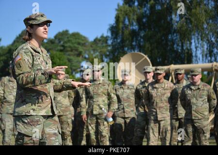 Stati Uniti Esercito Lt. Col. Heather McAteer, sinistra, comandante della 44th Expeditionary Battaglione di segnale, 2d teatro vigili del segnale, parla ai soldati poco prima il battaglione il mutamento della responsabilità cerimonia alla caserma della torre, Grafenwoehr, Germania, 27 luglio 2018. Foto Stock