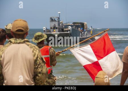 VIRGINIA BEACH, Va. (26 luglio 2018) un marinaio da unità Beachmaster 2 guide in un assalto unità artigianali (ACU) 2 Landing Craft Utility (LCU) 1600 a Utah Beach come parte di esercizio Trident Sun 18 a bordo comune Base Expeditionary Little Creek - Fort Story. Trident Sun 18 è un preposizionamento marittima forza (MPF) operazione destinata a fornire una formazione alla componente di riserva personale per quanto riguarda il flusso in offload di veicoli e attrezzature militari. Foto Stock