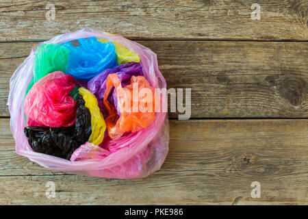 Diversi sacchetti di plastica su sfondo di legno. Foto Stock