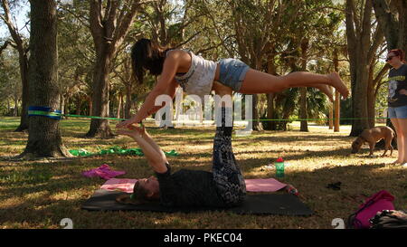 Giovani donne facendo pratica di acro yoga su un parco pubblico in Florida, Jupiter, Florida. Stati Uniti d'America - 17 giugno 2017. Foto Stock