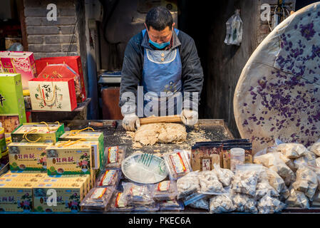 L'uomo facendo tradizionali dolci Cinesi in Luoyang Città Vecchia; Luoyang, nella provincia di Henan, Cina Foto Stock