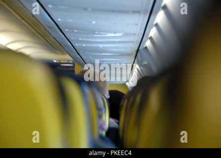 Guardando verso il basso la cabina aereo tra le sedi su un volo Ryanair Foto Stock